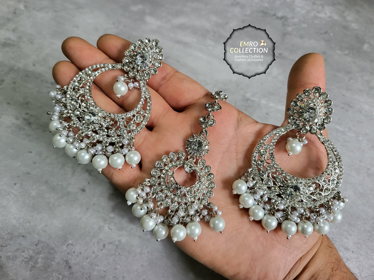 silver earrings and mang tikka set styled elegantly on a mannequin for a wedding jewelry look